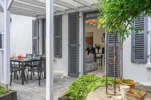 a patio with a table and a dining room at Imagine - Charmante maison avec jardin in Vannes