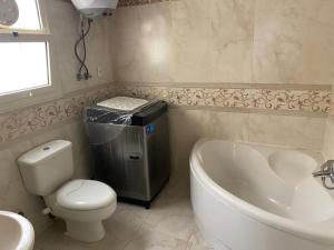 a bathroom with a tub and a toilet and a sink at Luxury apartment in front of the AUC in Cairo