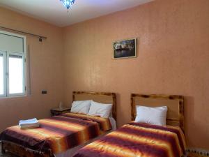 two beds in a room with a window at Birgits Bed & Bistro in Madkhal Meski