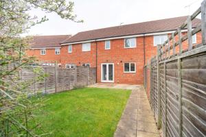 a brick house with a fence and a yard at Saltbox Stays - 3 Bed with off-street parking, fast Wifi, sleeps 7, Central location in Ashby de la Zouch