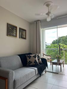 a living room with a couch and a large window at Hotel APART Zuccolotto 303 in Aracruz