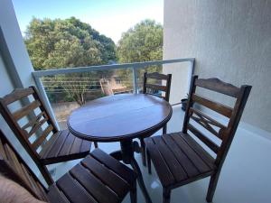 a wooden table and two chairs on a balcony at Hotel APART Zuccolotto 303 in Aracruz