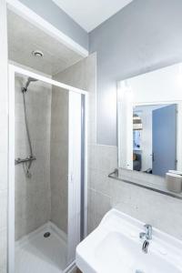 a bathroom with a shower and a sink and a mirror at L'unique in Saint-Étienne