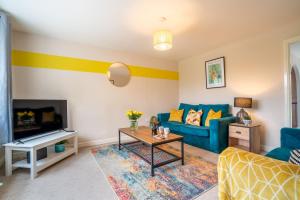 a living room with a blue couch and a tv at Saltbox Stays - 3 Bed with off-street parking, fast Wifi, sleeps 7, Central location in Ashby de la Zouch