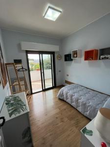 a bedroom with a bed and a sliding glass door at Appartamento ORNELLO in Pietrasanta