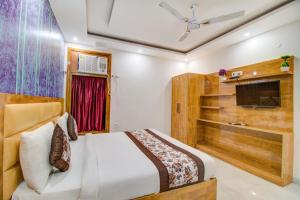 a bedroom with a bed and a tv in a room at FabHotel Gross Inn Suites in New Delhi