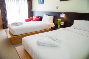 ein Hotelzimmer mit 2 Betten und einem Fenster in der Unterkunft Patong eyes in Patong Beach