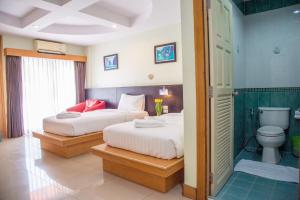 a hotel room with two beds and a bathroom at Patong eyes in Patong Beach
