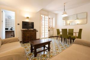 un soggiorno con TV, tavolo e sedie di Casa Ibiscus a Mondello
