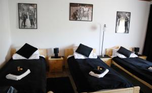 three beds in a room with black and white photos on the wall at Zum Burgkeller in Bruchweiler