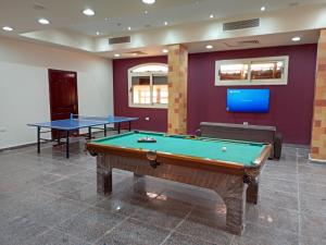 een biljartkamer met 2 tafels en een tv bij La Sirena Hotel & Resort - Families only in Ain Sokhna