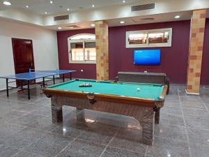 een biljartkamer met 2 tafels en een tv bij La Sirena Hotel & Resort - Families only in Ain Sokhna