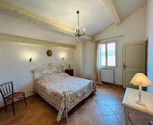 a bedroom with a bed and a table and a lamp at Château du Grand Jas in Entrecasteaux +32 photos