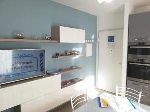 sala de estar con TV en la pared en Nuovissimo appartamento con terrazza en Alguer