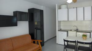 a kitchen with a couch and a table and a refrigerator at Apartamentos Amatista in Salou