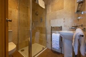 een badkamer met een douche, een wastafel en een toilet bij The White Swan in Scotter