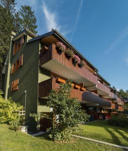 un edificio con un balcón con flores. en Mandron charming and central apartment en Madonna di Campiglio