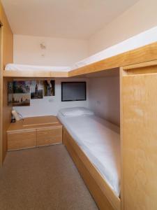a small bedroom with a bed and a tv at Mandron charming and central apartment in Madonna di Campiglio