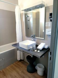 a bathroom with a sink and a mirror at Hotel de La Paix in Corte