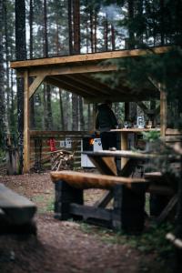 a man standing at a picnic table in a forest at Attla Skogsby in MÃ¥nsarp