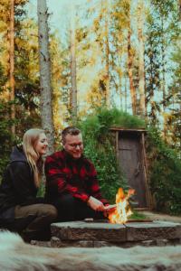 a man and woman sitting next to a fire at Attla Skogsby in MÃ¥nsarp