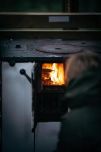 a person sitting in front of a fire oven at Attla Skogsby in MÃ¥nsarp