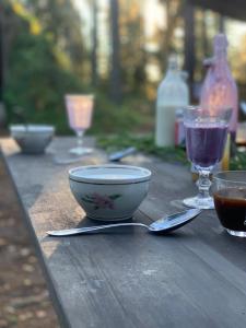 a wooden table with a bowl and glasses on it at Attla Skogsby in MÃ¥nsarp