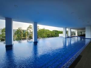 ein großer Pool mit blauem Wasser in einem Gebäude in der Unterkunft Taman Equine Comfy Studio#Greenery View#4 pax#Aeon Mall in Seri Kembangan