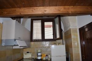 a kitchen with a white refrigerator and a window at Casa Muscettola in Leporano +17 photos
