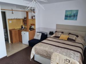 1 dormitorio con 1 cama y cocina pequeña en Marino, en Kołobrzeg