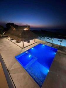 a swimming pool with blue lights on a house at Dianamar house, Te mereces disfrutarlo in Ríohacha