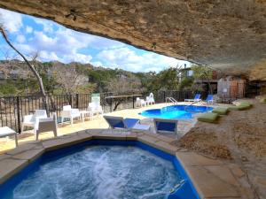 Un bain à remous est installé au milieu d'une terrasse avec des tables et des chaises. dans l'établissement Lakefront Bungalow With Pool & Hot Tub #4, à Lakeway