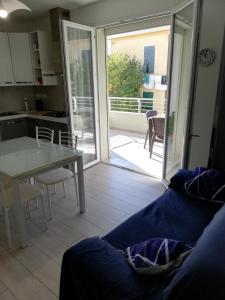 sala de estar con sofá, mesa y cocina en Nuovissimo appartamento con terrazza en Alguer