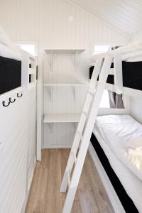 a bunk bed room with two bunk beds and a ladder at Lagunen Cottages and Hostel in Strömstad