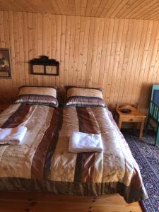 a bed in a room with a wooden wall at Seljaland ferðaþjónusta in Búðardalur