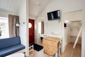 Lagunen Cottages and Hostel في سترومستاد: غرفة صغيرة مع أريكة زرقاء ومكتب