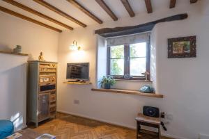 a living room with a tv and a window at Cosy Country Cottage with Stunning Views in Nailsworth in Nailsworth