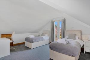 1 dormitorio con 2 camas y ventana en Modern 8-Bed Home - Parking, Wi-Fi, 5 mins to Town, en Gravesend