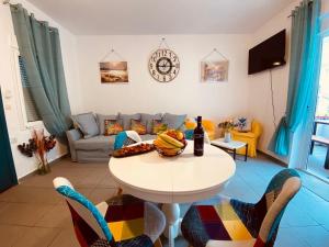 a living room with a table and a couch at Aquamarine Maisonette in Siviri