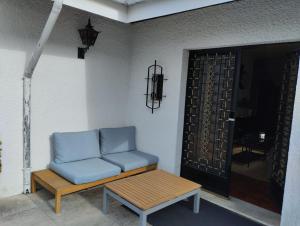 a blue couch sitting on a porch next to a door at Hostel Summer House in Vila Nova de Gaia