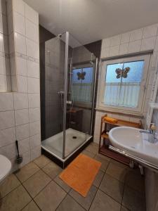 a bathroom with a shower and a tub and a sink at Am Deich 22 Strandfalter Zingst in Zingst