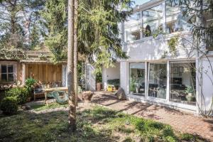 Ein Haus mit einer Terrasse mit einem Tisch und Stühlen in der Unterkunft Modernes Landapartment in Seevetal