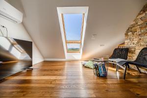 an attic living room with a large window at Mountain View Apartment with Sauna in Cerklje na Gorenjskem
