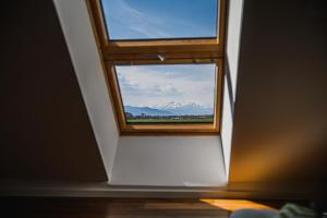 uma janela num quarto com vista para uma montanha em Mountain View Apartment with Sauna em Cerklje na Gorenjskem