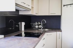 a kitchen with two sinks and white cabinets at Mountain View Apartment with Sauna in Cerklje na Gorenjskem