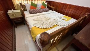 una cama de madera con sábanas blancas y almohadas. en Okay 1 Villa, en Siem Reap