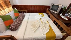 1 dormitorio con 1 cama y mesa con TV en Okay 1 Villa, en Siem Reap