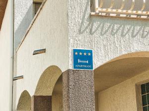 un panneau bleu sur le côté d'un bâtiment dans l'établissement Beach Apartment x2 Bedrooms w Sea View & 2x En-Suites, à Šibenik