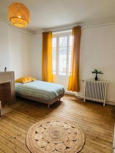 een slaapkamer met een bed en een tapijt op een houten vloer bij « Bel’ Epoque » proche vieille ville 6 pers, WIFI in Boulogne-sur-Mer