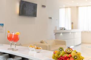 a table with a plate of fruit and a drink at Hb Hotels Orchidea Blu in Rimini